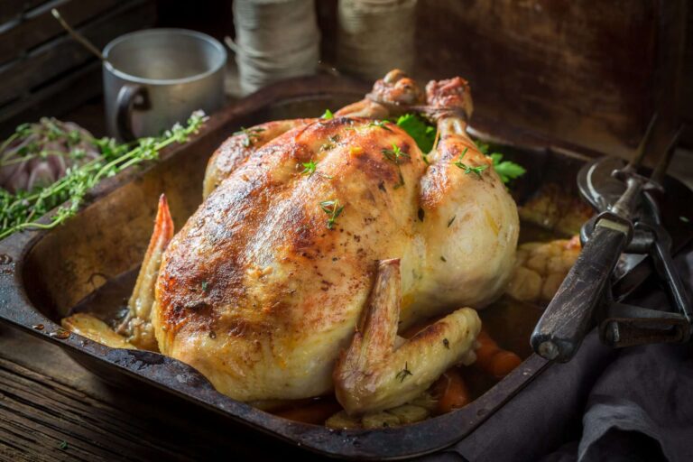 A whole roasted chicken served on a platter, ready for a group dinner.